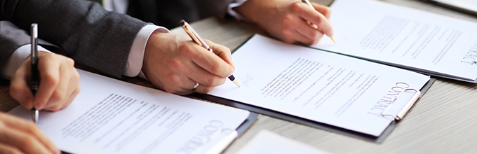 Hands signing a document